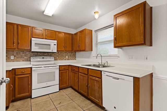 2605 Little Nolan Rd, Killeen, TX 76542 - kitchen featuring white appliances, a sink, brown cabinets, light countertops, and light tile patterned flooring