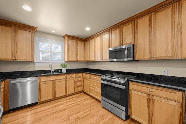 3214 Funston St, Austin, TX 78703 - kitchen with appliances with stainless steel finishes, light wood finished floors, recessed lighting, and dark stone counters