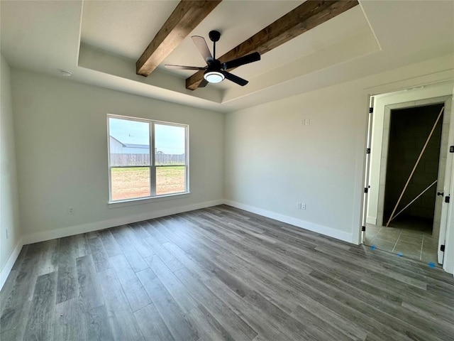 5501 Hollow Loop, Salado, TX 76571 - empty room featuring wood finished floors, baseboards, beam ceiling, a ceiling fan, and a tray ceiling