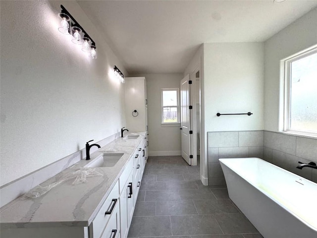 5501 Hollow Loop, Salado, TX 76571 - full bathroom with plenty of natural light, double vanity, a freestanding tub, and tile patterned floors