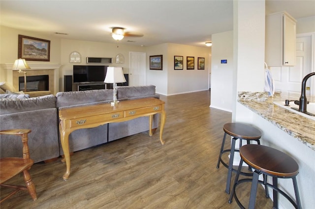 living area featuring wood finished floors, baseboards, and a tile fireplace