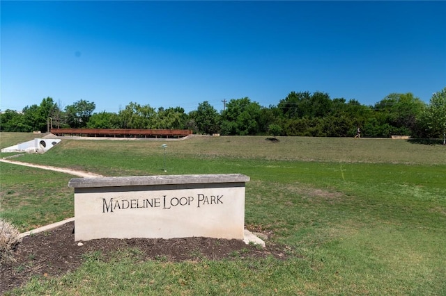 community / neighborhood sign featuring a yard