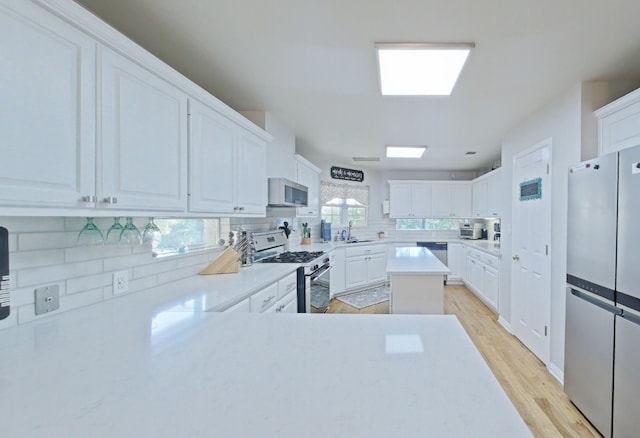 1127 Penion Dr, Austin, TX 78748 - kitchen featuring appliances with stainless steel finishes, decorative backsplash, light countertops, and white cabinetry