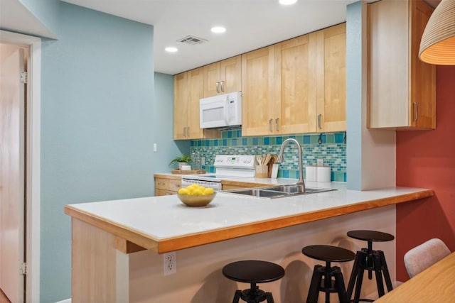 2104 Cullen Ave Unit 223, Austin, TX 78757 - kitchen with white appliances, a sink, tasteful backsplash, a kitchen breakfast bar, and light brown cabinetry