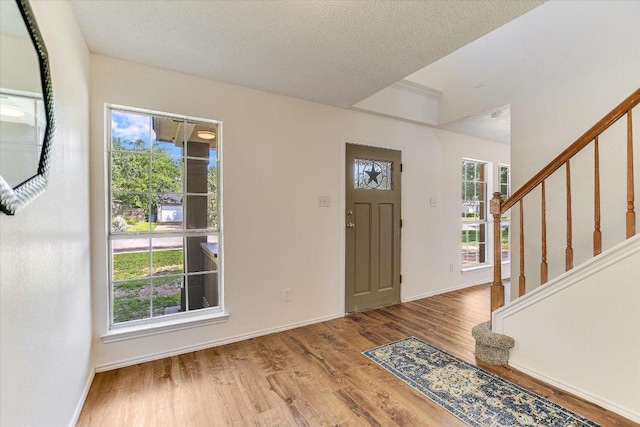 1905 Hollow Tree Blvd, Round Rock, TX 78681 - foyer entrance featuring wood finished floors, healthy amount of natural light, stairway, baseboards, and a textured ceiling