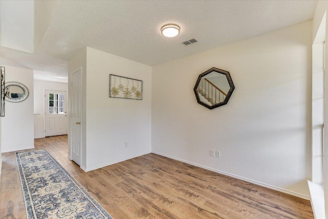 1905 Hollow Tree Blvd, Round Rock, TX 78681 - empty room with light wood-style flooring, baseboards, and a textured ceiling