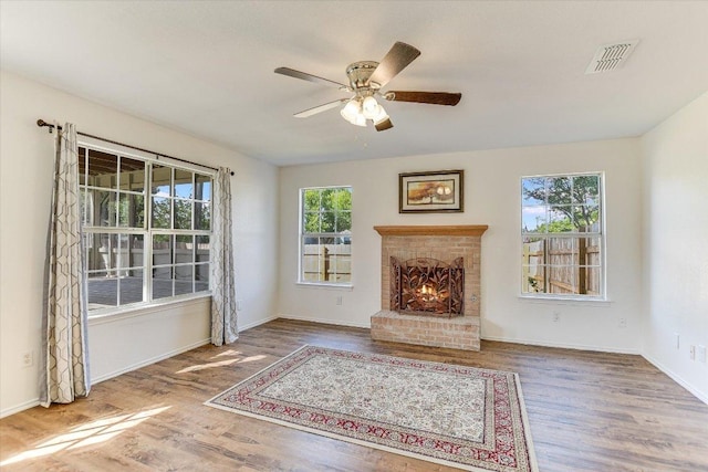 1905 Hollow Tree Blvd, Round Rock, TX 78681 - unfurnished living room with wood finished floors, ceiling fan, a brick fireplace, and baseboards
