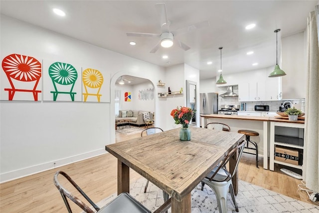1901 E 10th St, Austin, TX 78702 - dining room featuring ceiling fan, light wood-style flooring, arched walkways, and recessed lighting