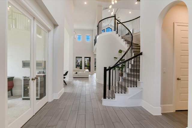 604 Rawson Bnd, Austin, TX 78738 - entryway with wood finished floors, french doors, a high ceiling, arched walkways, and stairway