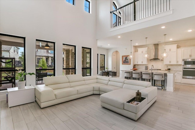 604 Rawson Bnd, Austin, TX 78738 - living room with a towering ceiling, arched walkways, a ceiling fan, light wood-style floors, and recessed lighting