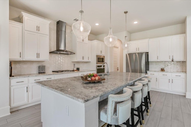 604 Rawson Bnd, Austin, TX 78738 - kitchen with wall chimney range hood, stainless steel appliances, decorative backsplash, white cabinetry, and recessed lighting