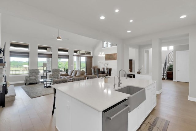 kitchen with a sink, stainless steel dishwasher, recessed lighting, plenty of natural light, and light wood-style flooring