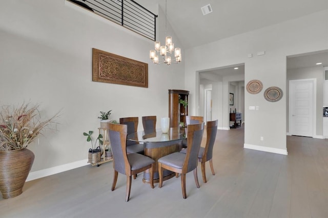 dining area with a high ceiling, wood finished floors, a chandelier, baseboards, and recessed lighting