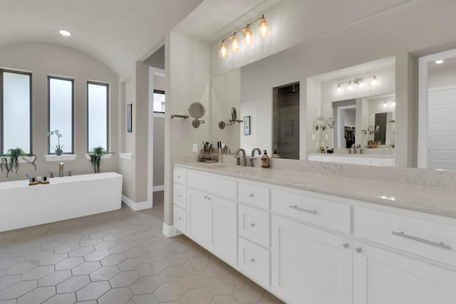 bathroom with a freestanding tub, tile patterned floors, a walk in shower, vanity, and vaulted ceiling