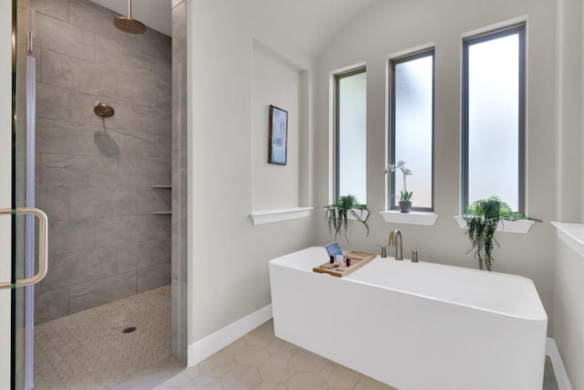 full bath with a shower stall, baseboards, a freestanding bath, and tile patterned flooring