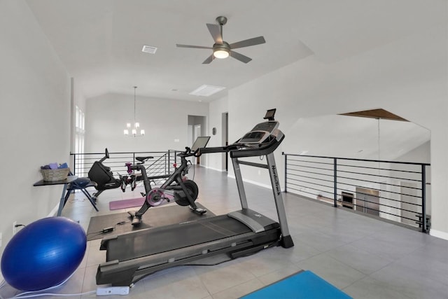 workout area featuring a chandelier, a ceiling fan, baseboards, and vaulted ceiling