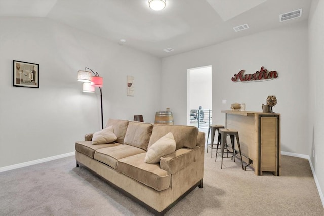 living area with light colored carpet, lofted ceiling, and baseboards