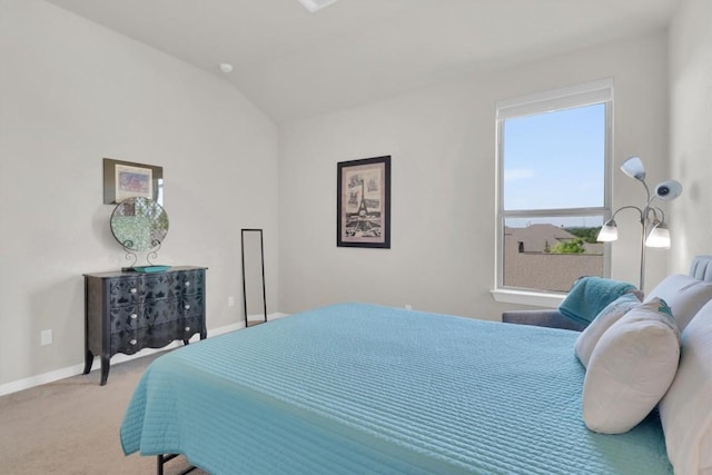carpeted bedroom with baseboards and lofted ceiling