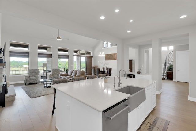 kitchen with a sink, dishwasher, recessed lighting, open floor plan, and healthy amount of natural light