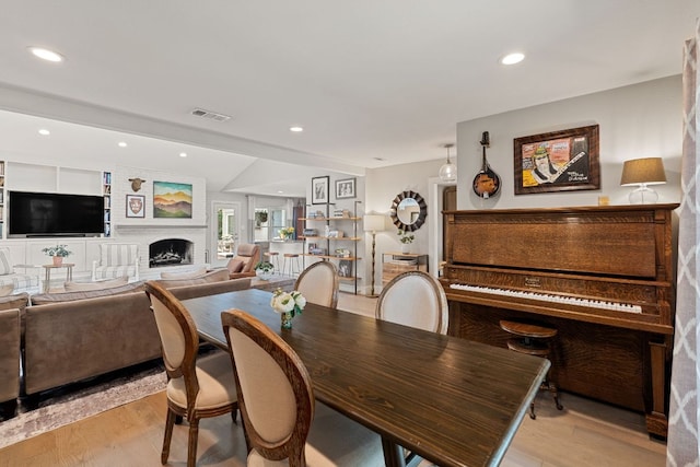 4107 Circletree Loop, Austin, TX 78731 - dining room with light wood-style flooring, a brick fireplace, and recessed lighting