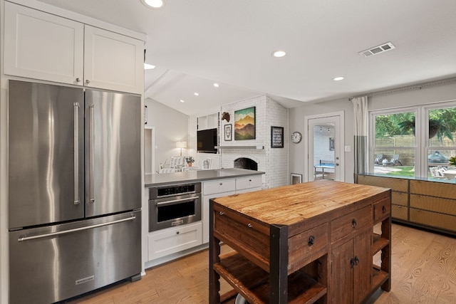 4107 Circletree Loop, Austin, TX 78731 - kitchen featuring appliances with stainless steel finishes, light wood-type flooring, white cabinetry, vaulted ceiling, and recessed lighting