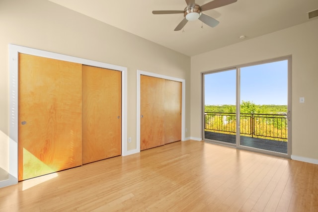 5309 Sendero Hills Pkwy, Austin, TX 78724 - unfurnished bedroom featuring access to exterior, light wood-style flooring, two closets, baseboards, and ceiling fan