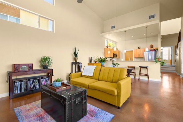 5309 Sendero Hills Pkwy, Austin, TX 78724 - living area with high vaulted ceiling, healthy amount of natural light, baseboards, and finished concrete floors