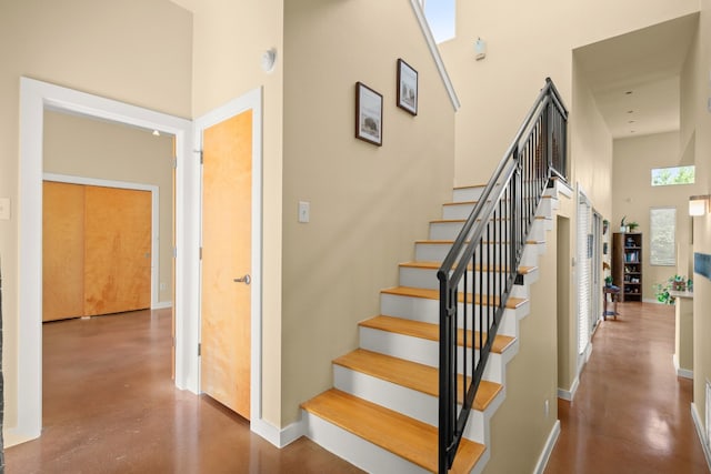 5309 Sendero Hills Pkwy, Austin, TX 78724 - staircase featuring finished concrete floors, a towering ceiling, and baseboards