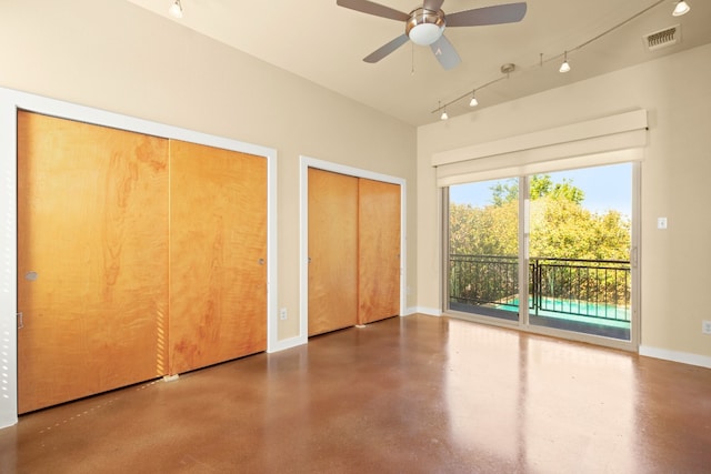 5309 Sendero Hills Pkwy, Austin, TX 78724 - unfurnished bedroom featuring two closets, access to outside, concrete floors, rail lighting, and baseboards