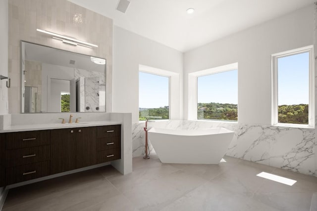 3401 Day Star Cv, Austin, TX 78746 - bathroom with tile walls, healthy amount of natural light, vanity, a soaking tub, and wainscoting