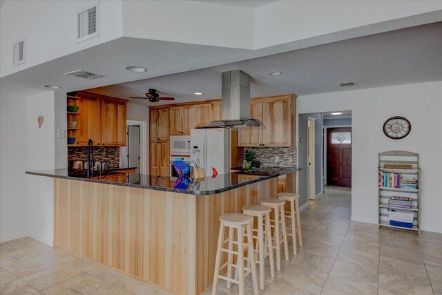 6022 Abilene Trl, Austin, TX 78749 - kitchen featuring white appliances, range hood, decorative backsplash, a peninsula, and recessed lighting