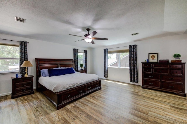 6022 Abilene Trl, Austin, TX 78749 - bedroom featuring a textured ceiling, light wood-style floors, and ceiling fan
