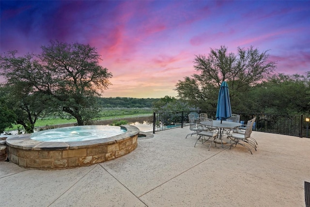 1348 Lake Shore Dr, Spicewood, TX 78669 - patio terrace at dusk featuring an in-ground hot tub, a patio area, and outdoor dining area