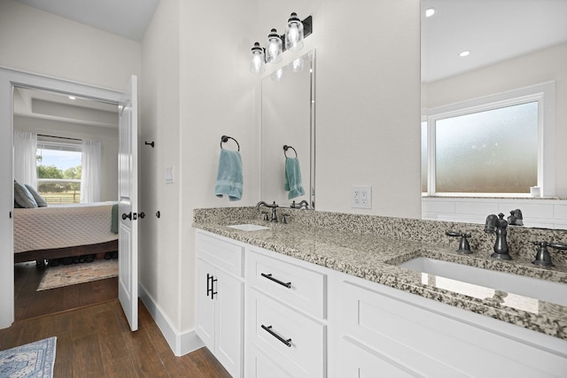 121 Gloria Blvd, Smithville, TX 78957 - bathroom featuring ensuite bath, wood finished floors, double vanity, baseboards, and recessed lighting