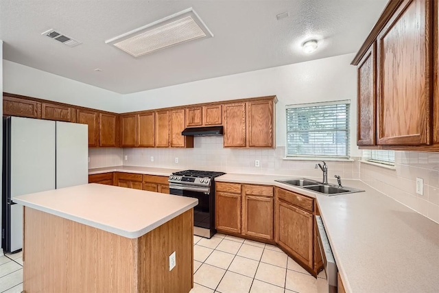 4712 Ramies Run, Austin, TX 78749 - kitchen with stainless steel appliances, under cabinet range hood, light tile patterned floors, and backsplash