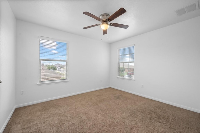 empty room featuring carpet floors, baseboards, and a ceiling fan