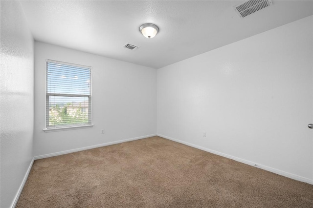 carpeted empty room featuring baseboards