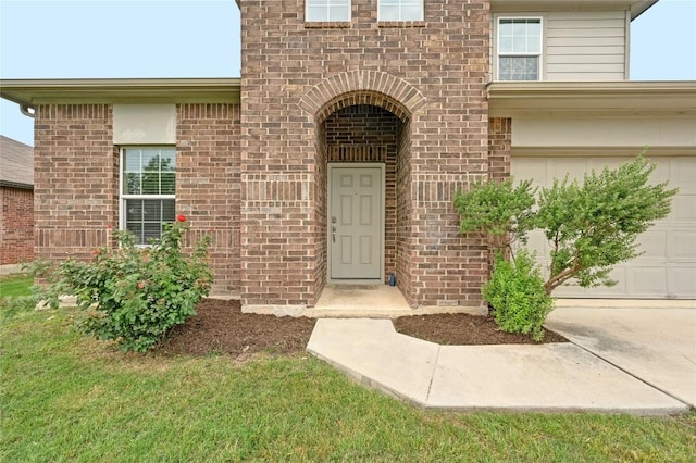 doorway to property with brick siding and an attached garage