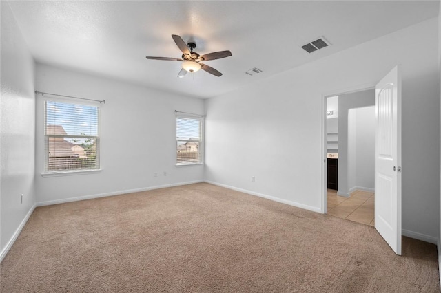 unfurnished room with light colored carpet, healthy amount of natural light, ceiling fan, and baseboards