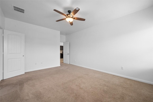 unfurnished room featuring ceiling fan, light colored carpet, and baseboards