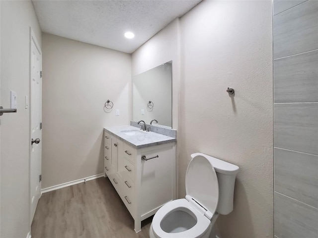 9512 Meadowheath Dr, Austin, TX 78729 - bathroom with wood finished floors, vanity, toilet, a textured ceiling, and baseboards