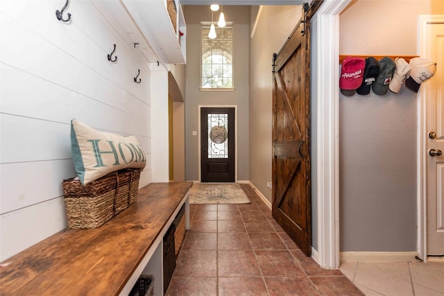 1006 Savanna Ln, Cedar Park, TX 78613 - mudroom featuring a barn door, tile patterned floors, and baseboards