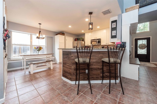 1006 Savanna Ln, Cedar Park, TX 78613 - kitchen with appliances with stainless steel finishes, a peninsula, tasteful backsplash, recessed lighting, and white cabinets