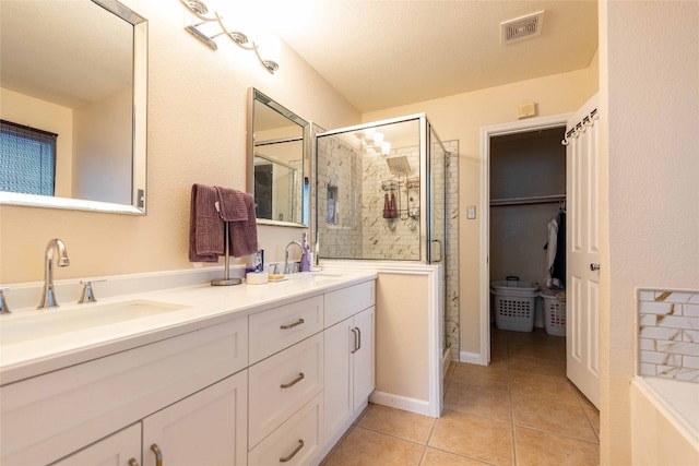 1006 Savanna Ln, Cedar Park, TX 78613 - bathroom with a stall shower, double vanity, tile patterned flooring, and a walk in closet