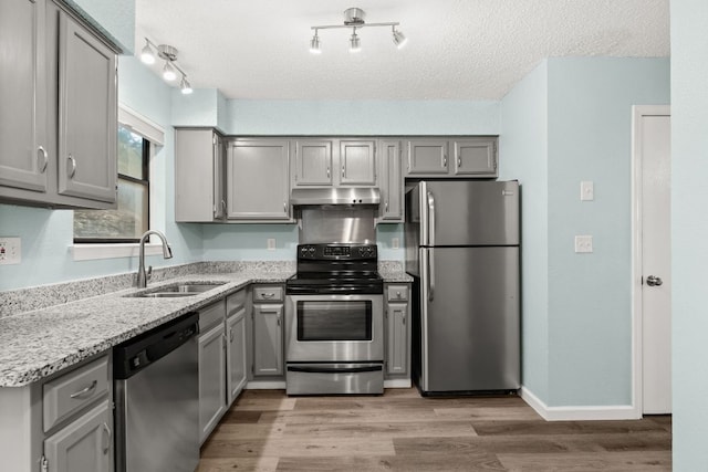 21459 Coyote Trl Unit A2, Lago Vista, TX 78645 - kitchen featuring stainless steel appliances, a sink, gray cabinetry, under cabinet range hood, and a textured ceiling
