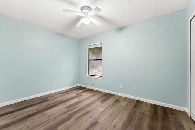 21459 Coyote Trl Unit A2, Lago Vista, TX 78645 - empty room featuring wood finished floors, a textured ceiling, ceiling fan, and baseboards