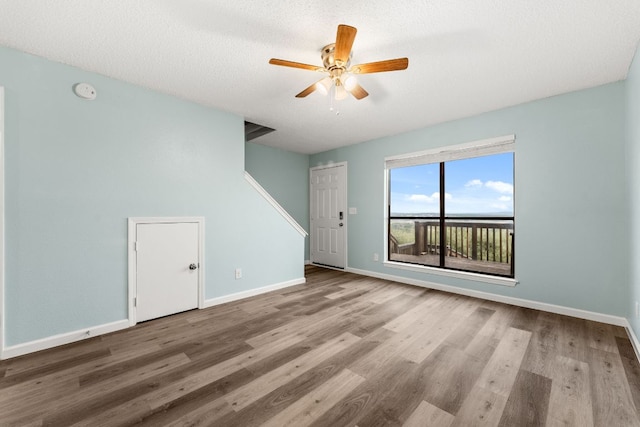 21459 Coyote Trl Unit A2, Lago Vista, TX 78645 - unfurnished living room with wood finished floors, ceiling fan, and a textured ceiling