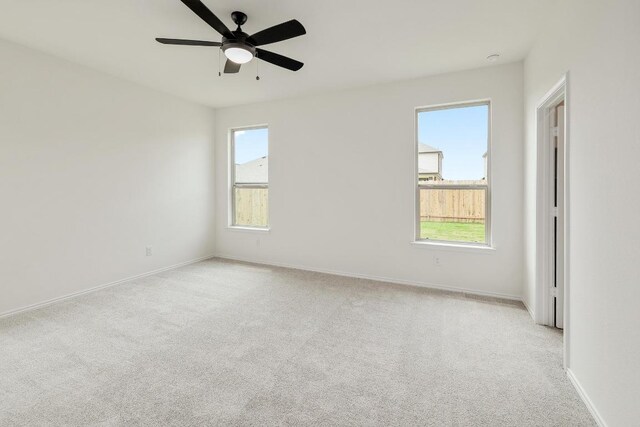 4923 Mozzafiato Ln, Round Rock, TX 78665 - spare room featuring light carpet, baseboards, and ceiling fan