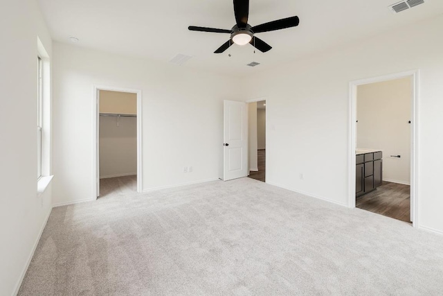 4923 Mozzafiato Ln, Round Rock, TX 78665 - unfurnished bedroom featuring carpet flooring, baseboards, a walk in closet, ceiling fan, and a closet