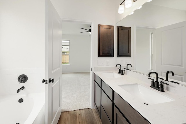4923 Mozzafiato Ln, Round Rock, TX 78665 - bathroom with a tub to relax in, wood finished floors, a ceiling fan, and double vanity